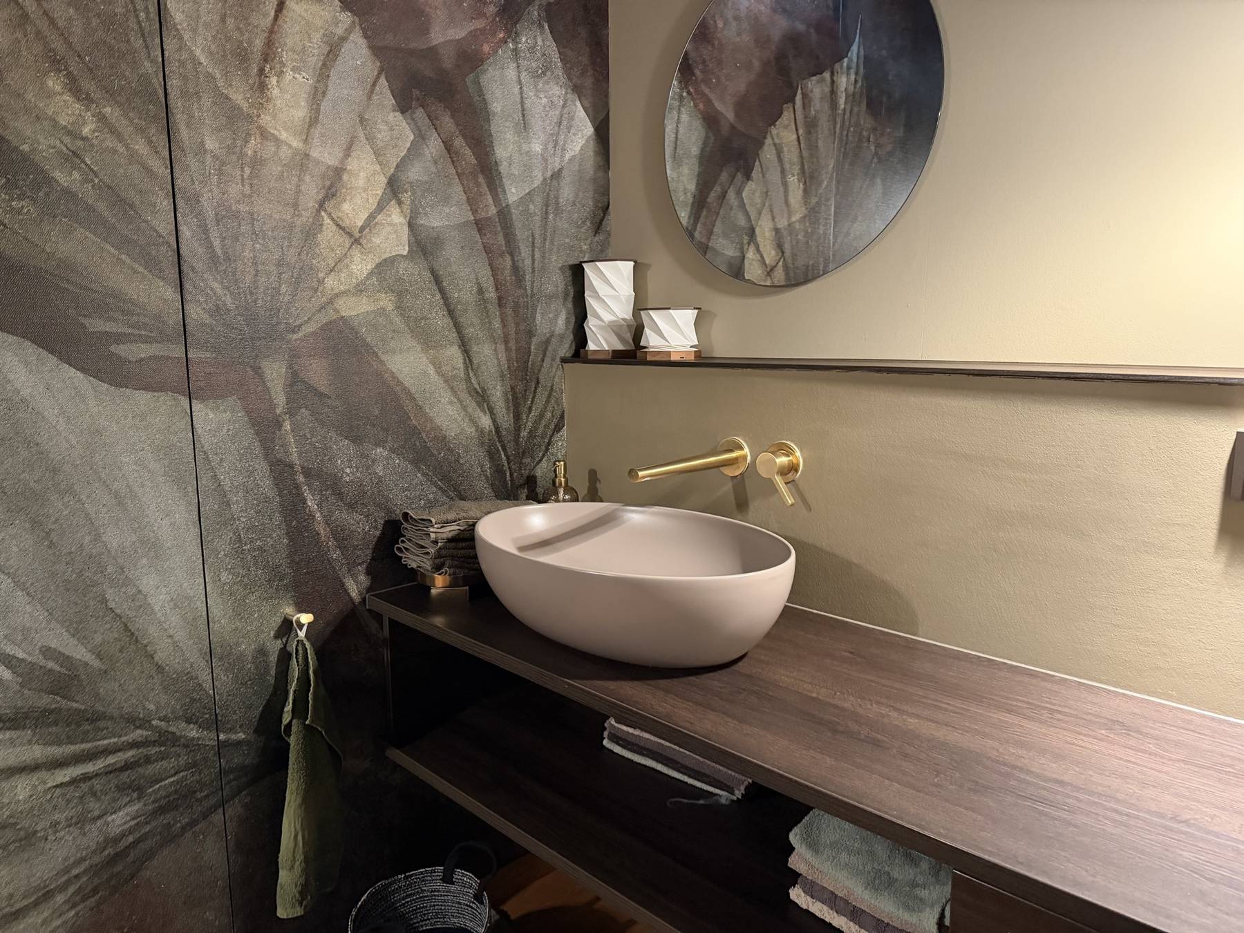 Aufsatzwaschbecken mit goldener Wandarmatur vor Motivtapete