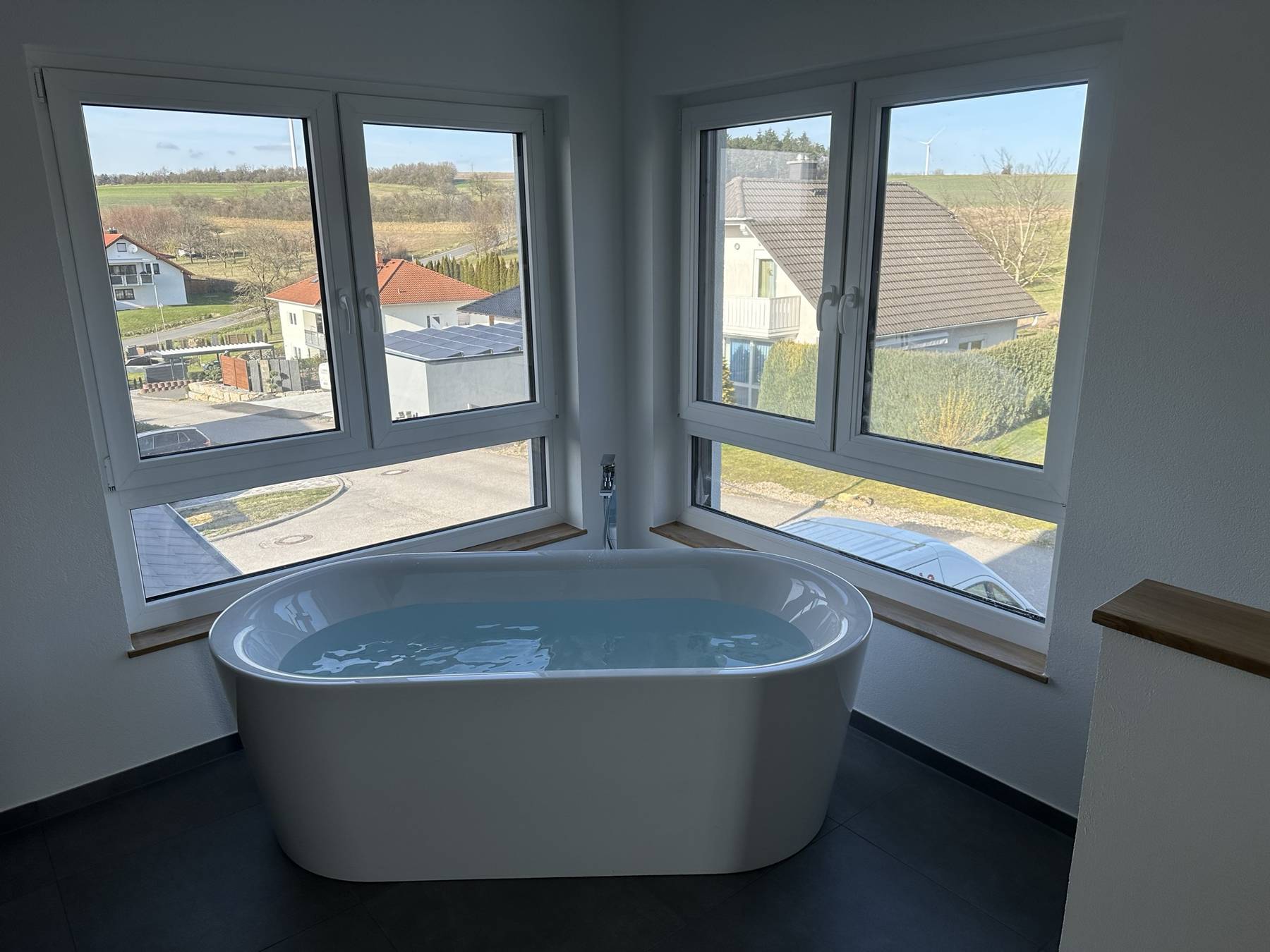 Freistehende Badewanne vor Eckfenster