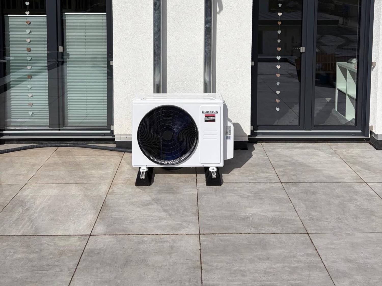 Außengerät einer Klimaanlage auf der Terrasse eines Wohnhauses